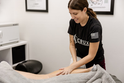 Massage therapist treating muscle tightness at a chiropractic clinic in St. George, Utah.