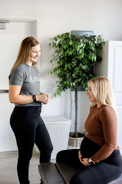 Chiropractor consulting with a pregnant patient at a clinic in St. George, Utah.