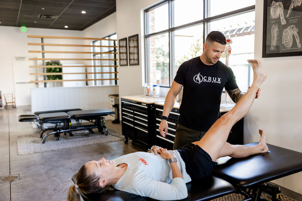 Chiropractor testing hamstring tightness on a professional triathlete at Crux Sport & Spine in St. George, Utah.