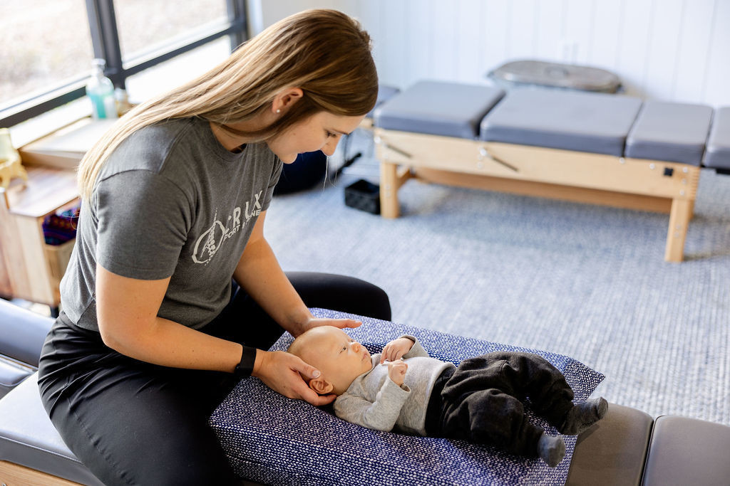 Chiropractor gently performing an adjustment on an infant at a clinic in St. George, Utah.