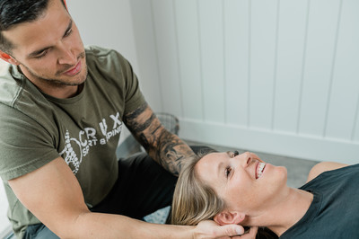 Woman laying on a table receiving a chiropractic adjustment form a chiropractor